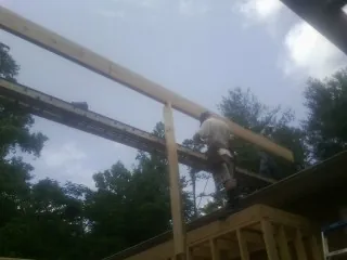 Carpenter setting a ridge beam over a new addition frame — Ice Dam Removal by Roofing Brothers in Rosedale