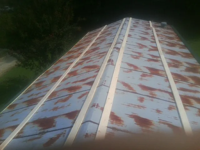 Rusted metal roof panels with new wood purlins before replacement — Storm Damage Roof Repair in Rosedale by Roofing Brothers